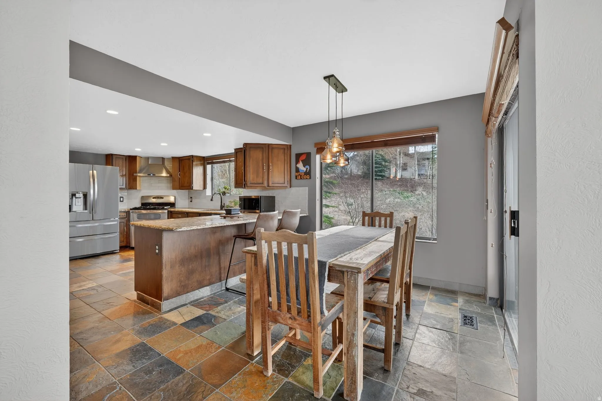 Dining space featuring stone tile flooring and recessed lighting