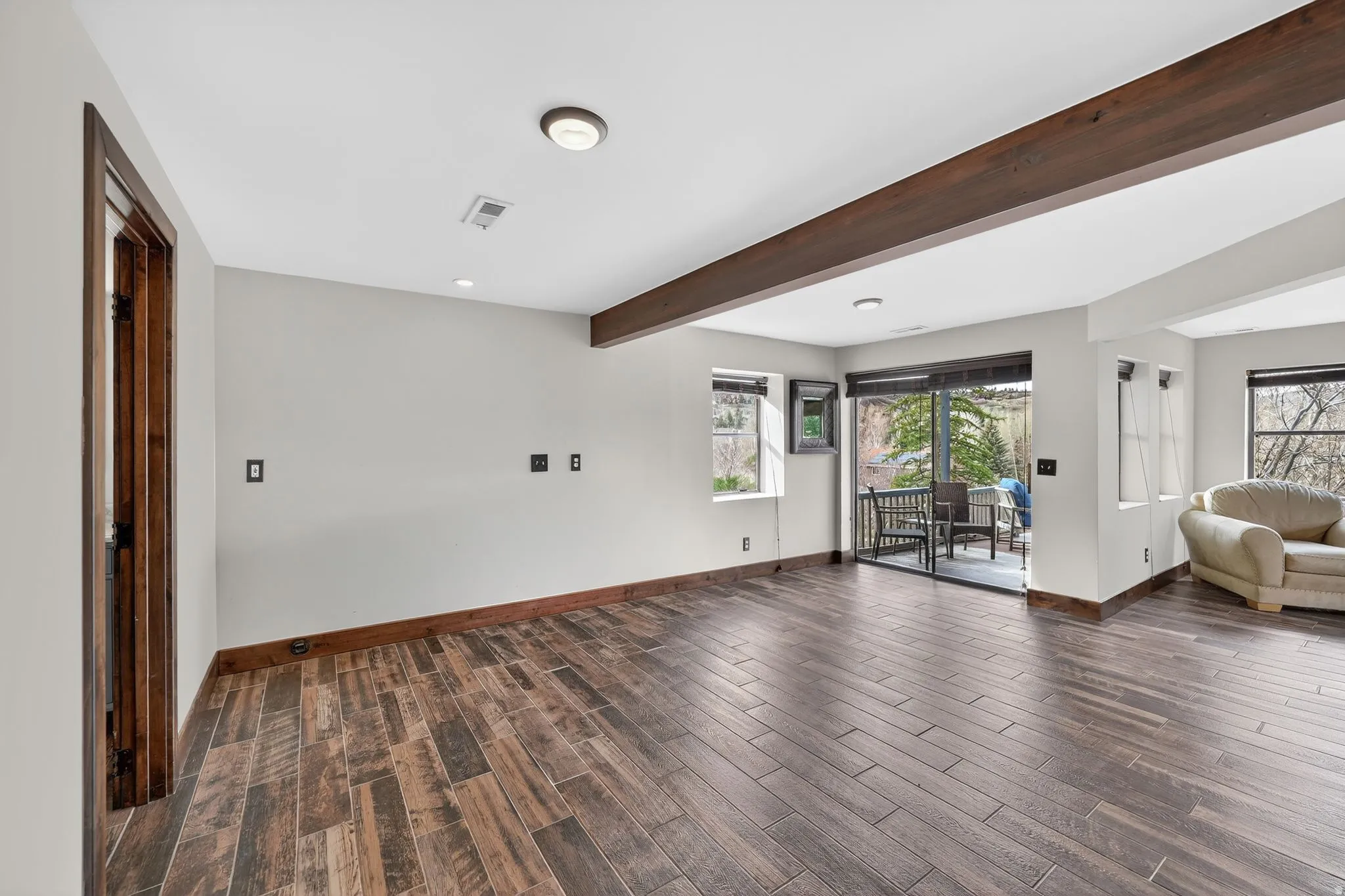 Living room with wood tiled floors, recessed lighting, and beamed ceiling