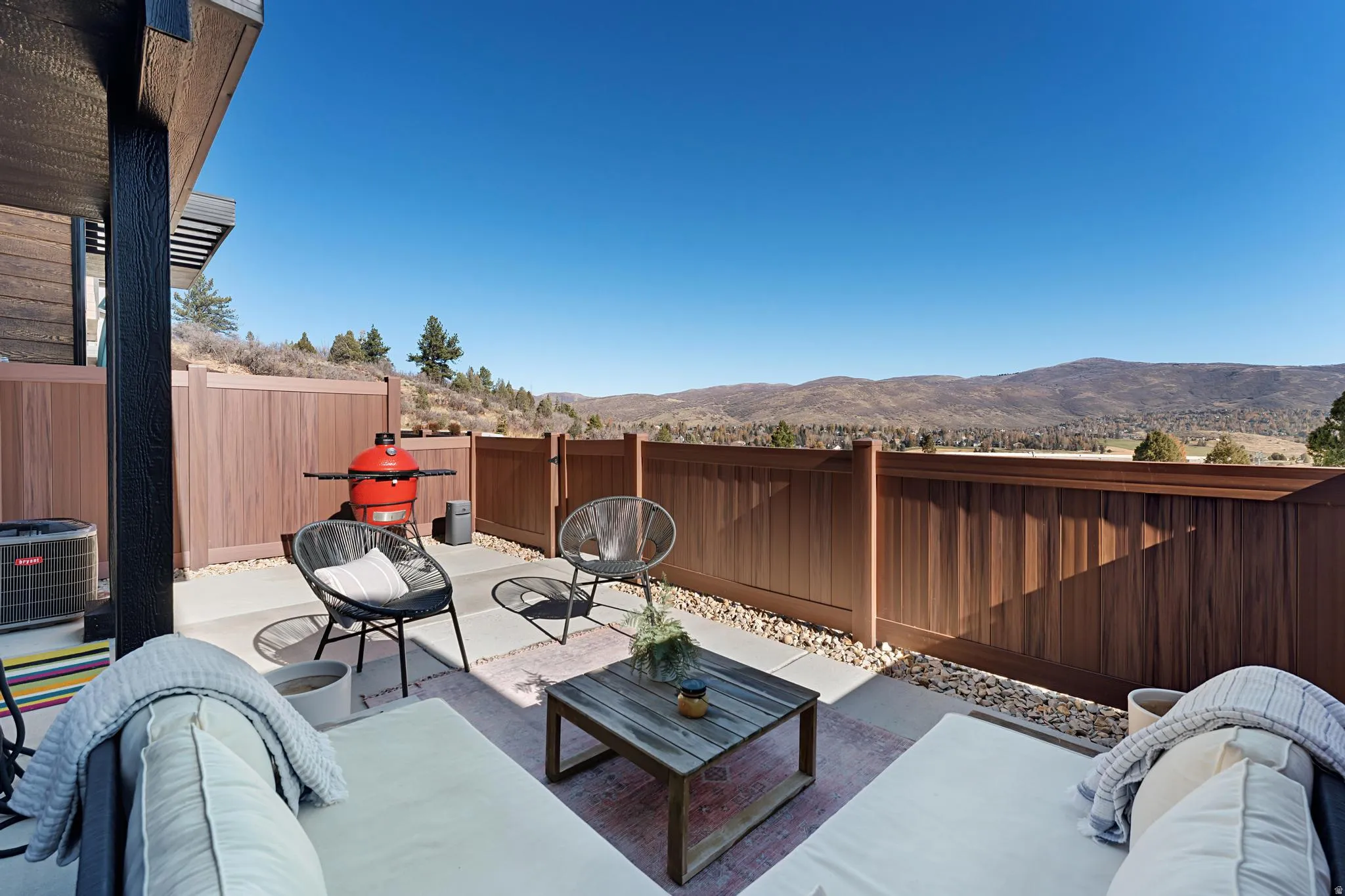 Fenced backyard featuring a patio area, a mountain view, and an outdoor hangout area