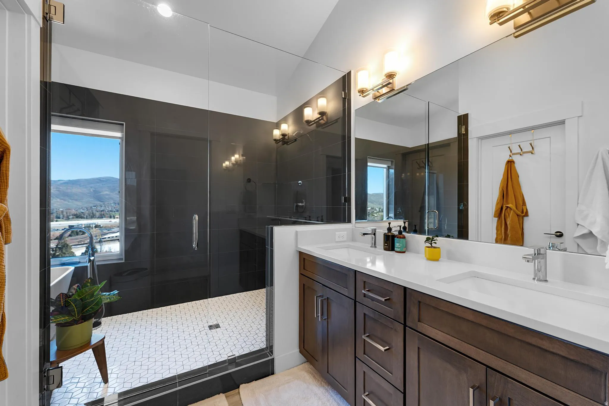 Full bath with double vanity and a stall shower