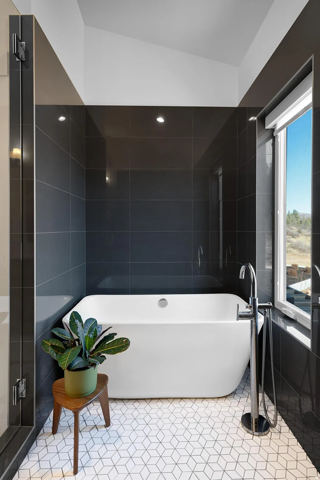 Full bath featuring a freestanding tub, light tile patterned flooring, and tile walls