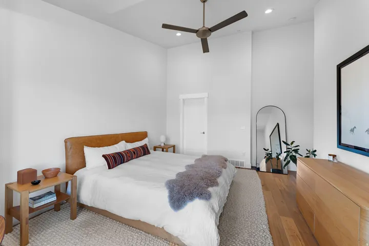 Bedroom featuring a high ceiling, hardwood / wood-style floors, ceiling fan, and recessed lighting