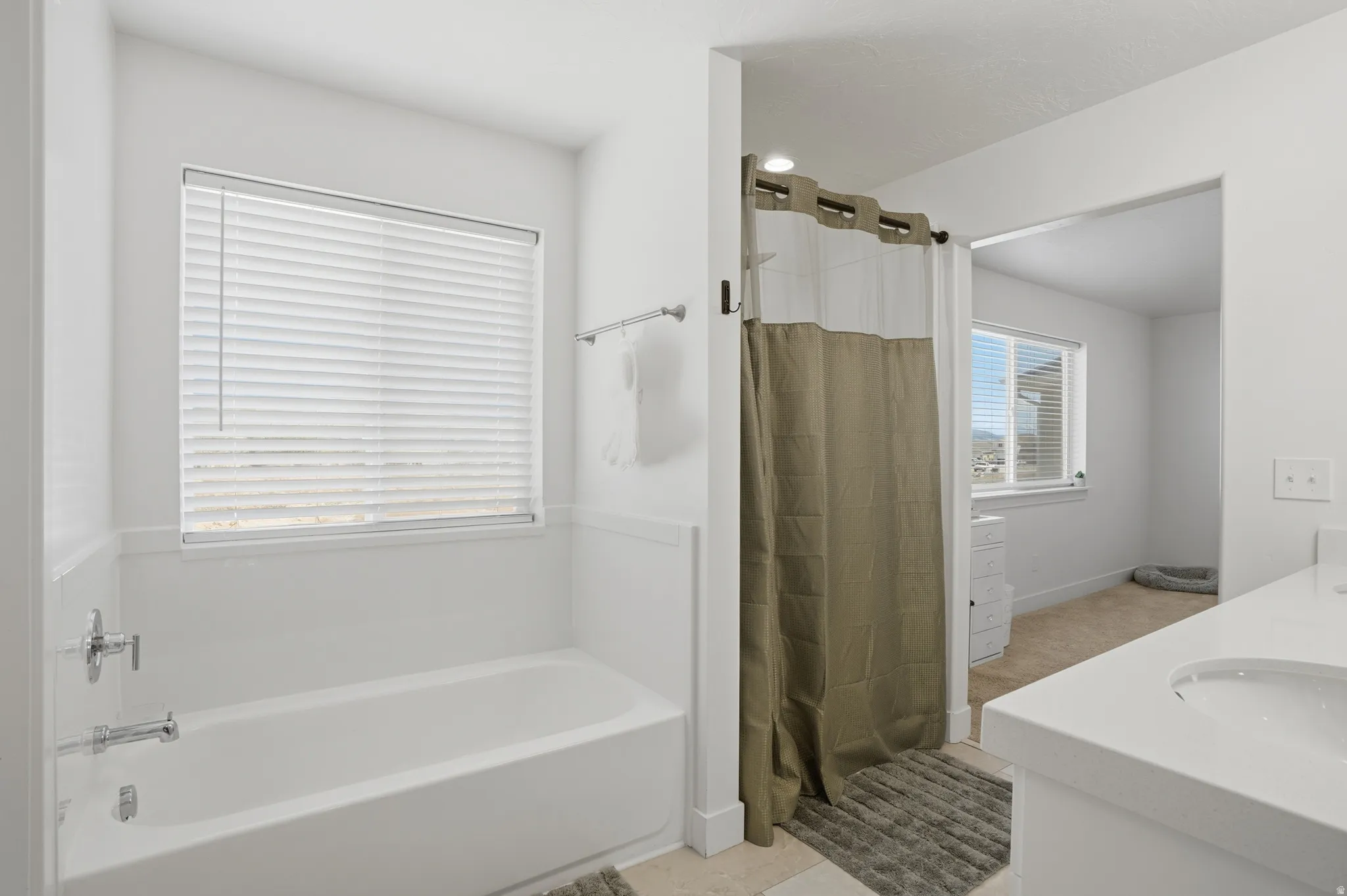 Full bath with vanity, a bath, a shower stall, and light tile patterned flooring