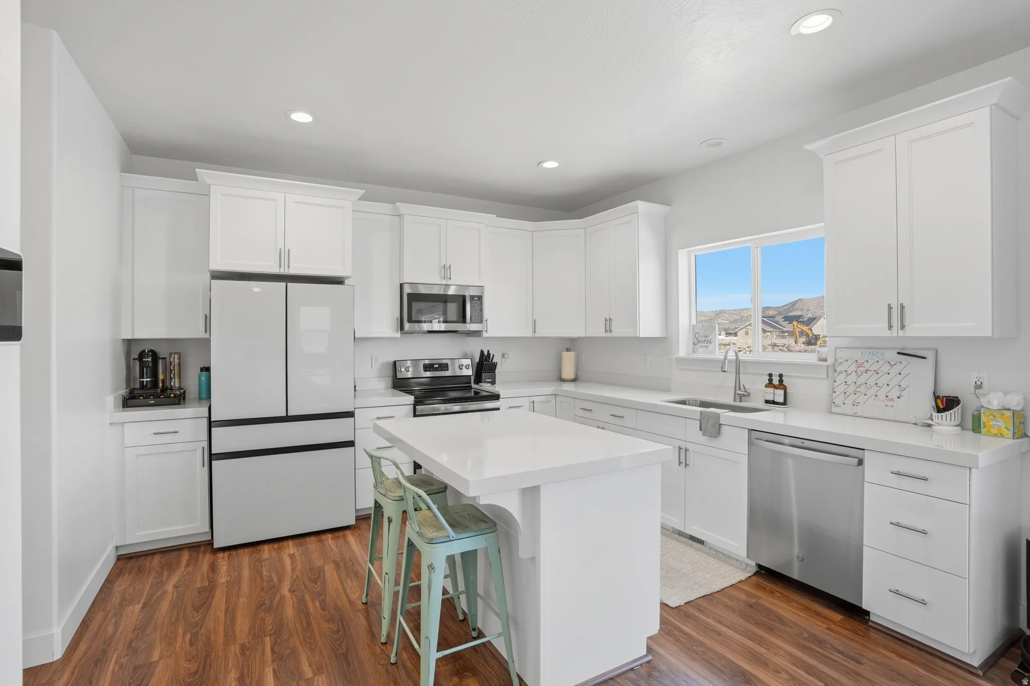 Kitchen featuring stainless steel appliances, a breakfast bar, white cabinetry, a center island, and recessed lighting