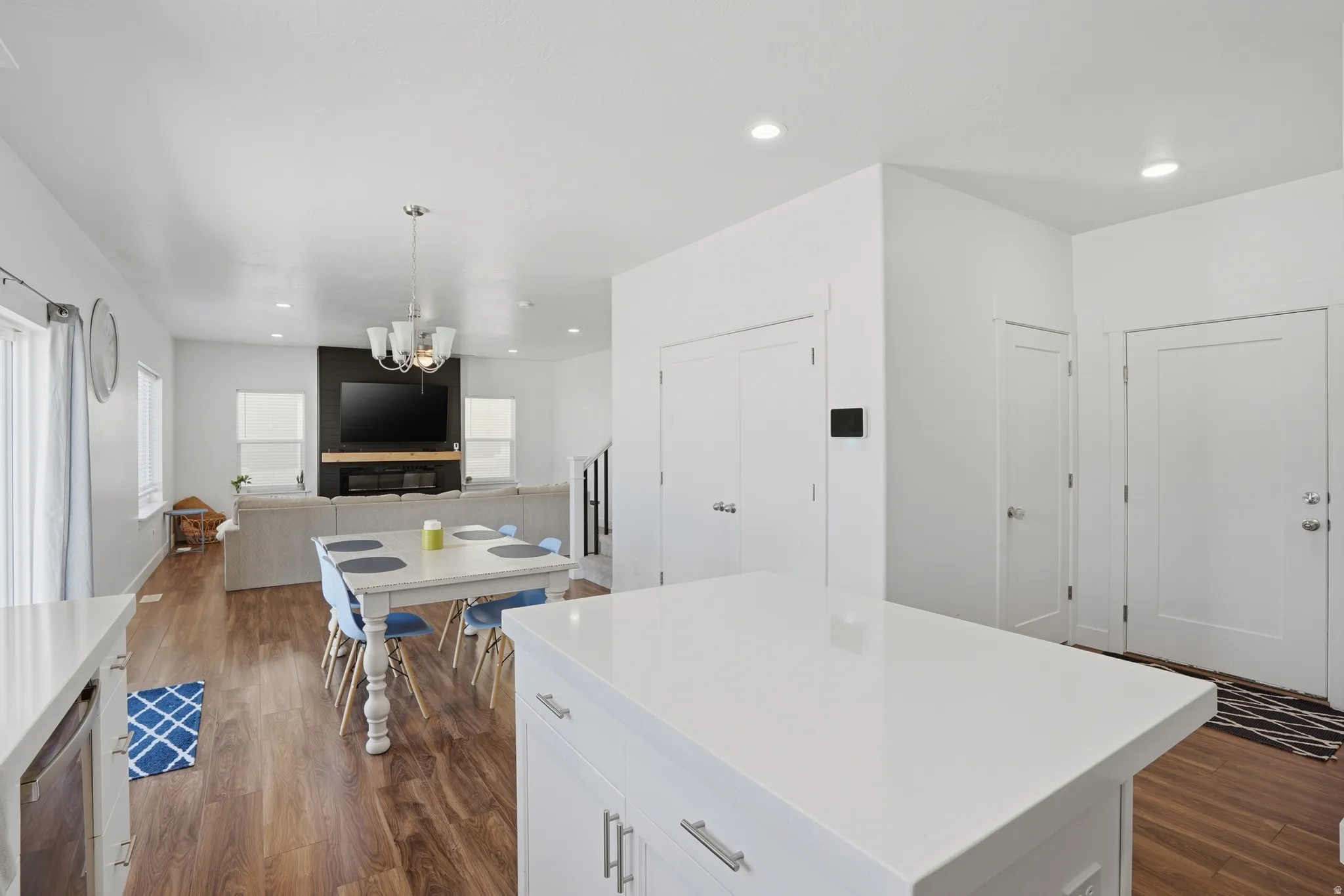 Kitchen featuring dark wood-type flooring, open floor plan, a kitchen island, a chandelier, and white cabinets