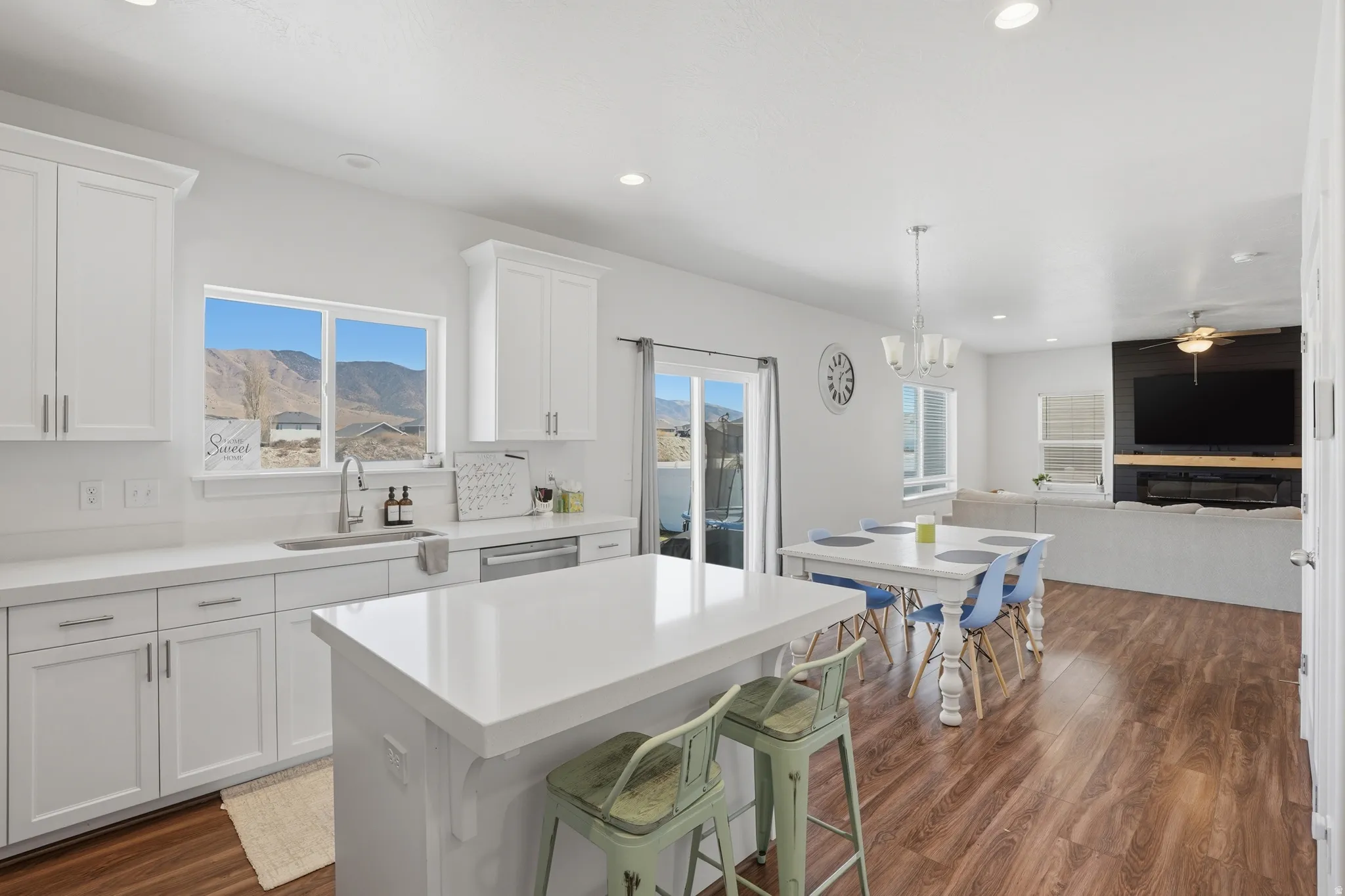 Kitchen with white cabinets, dark wood-style flooring, a kitchen breakfast bar, and a center island