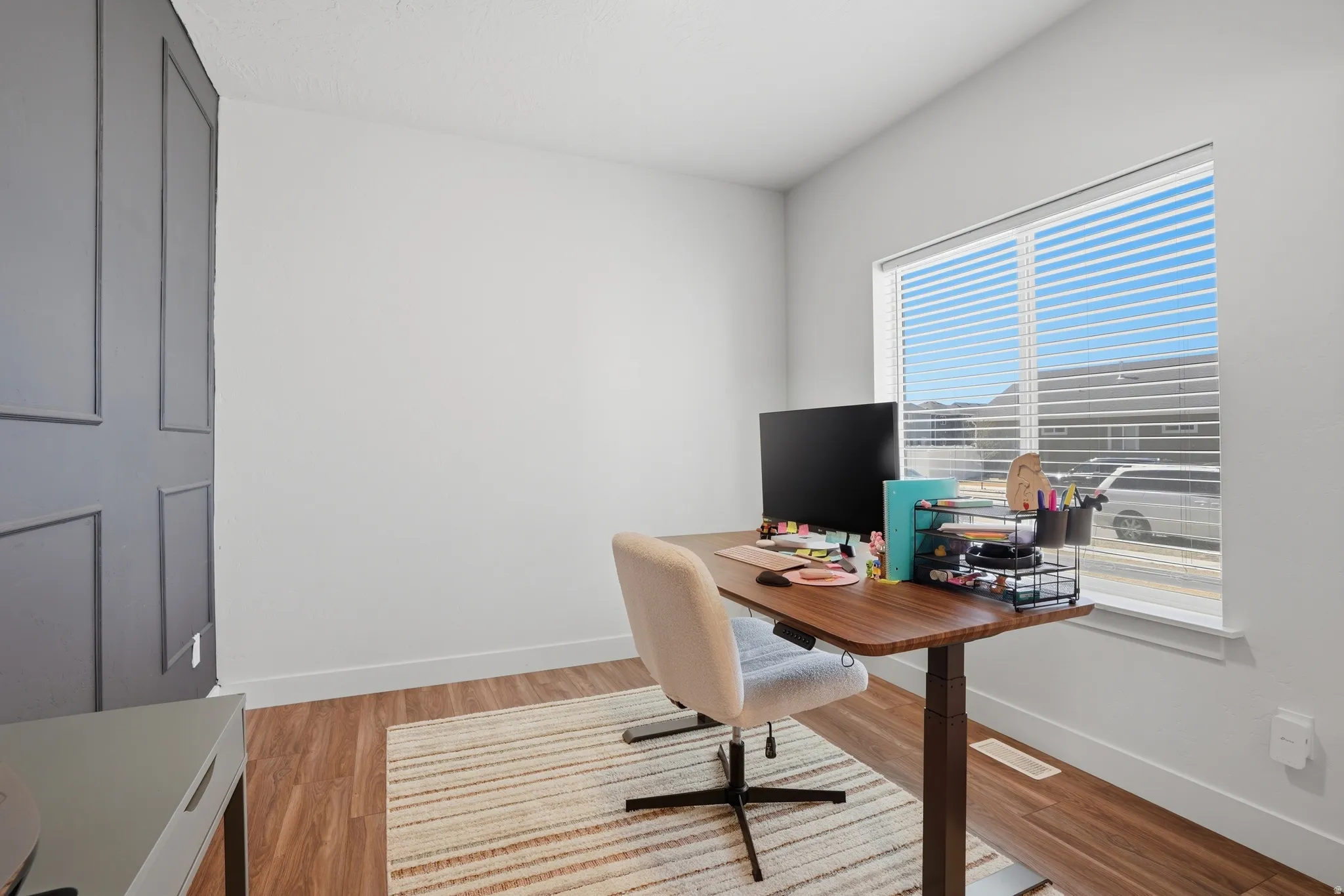 Office space with light wood-style flooring and baseboards
