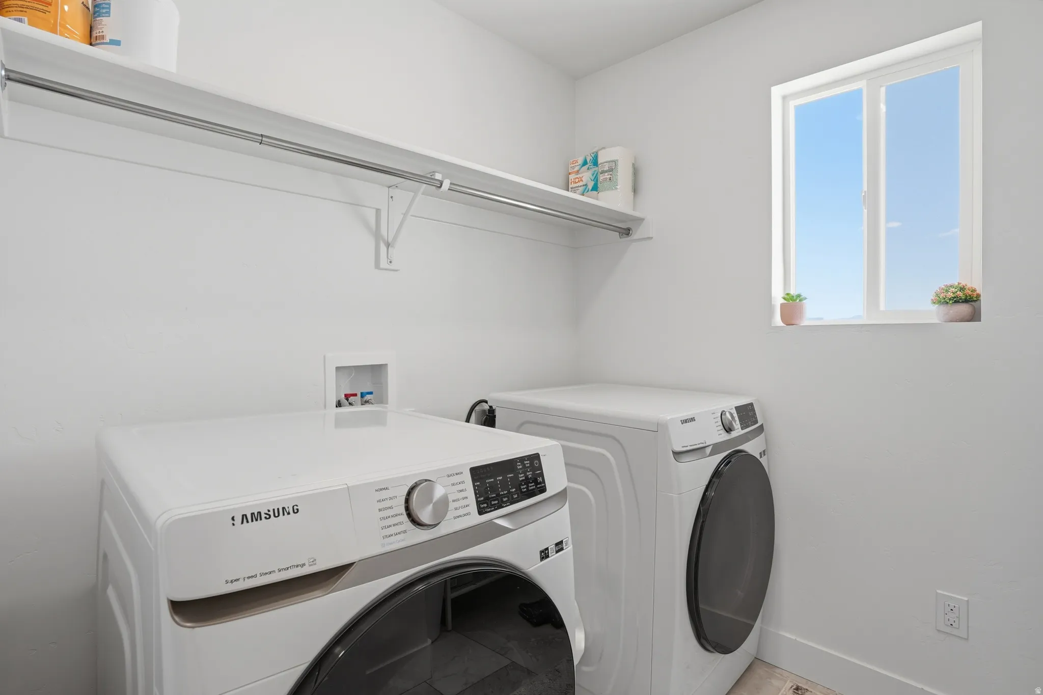 Laundry room with independent washer and dryer and baseboards