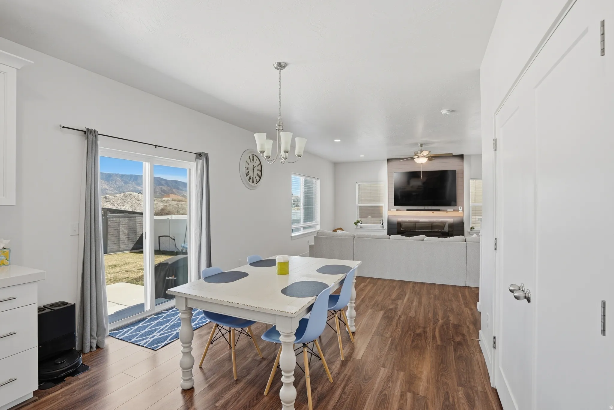Dining area with dark wood-style floors, healthy amount of natural light, hanging lights, and a ceiling fan