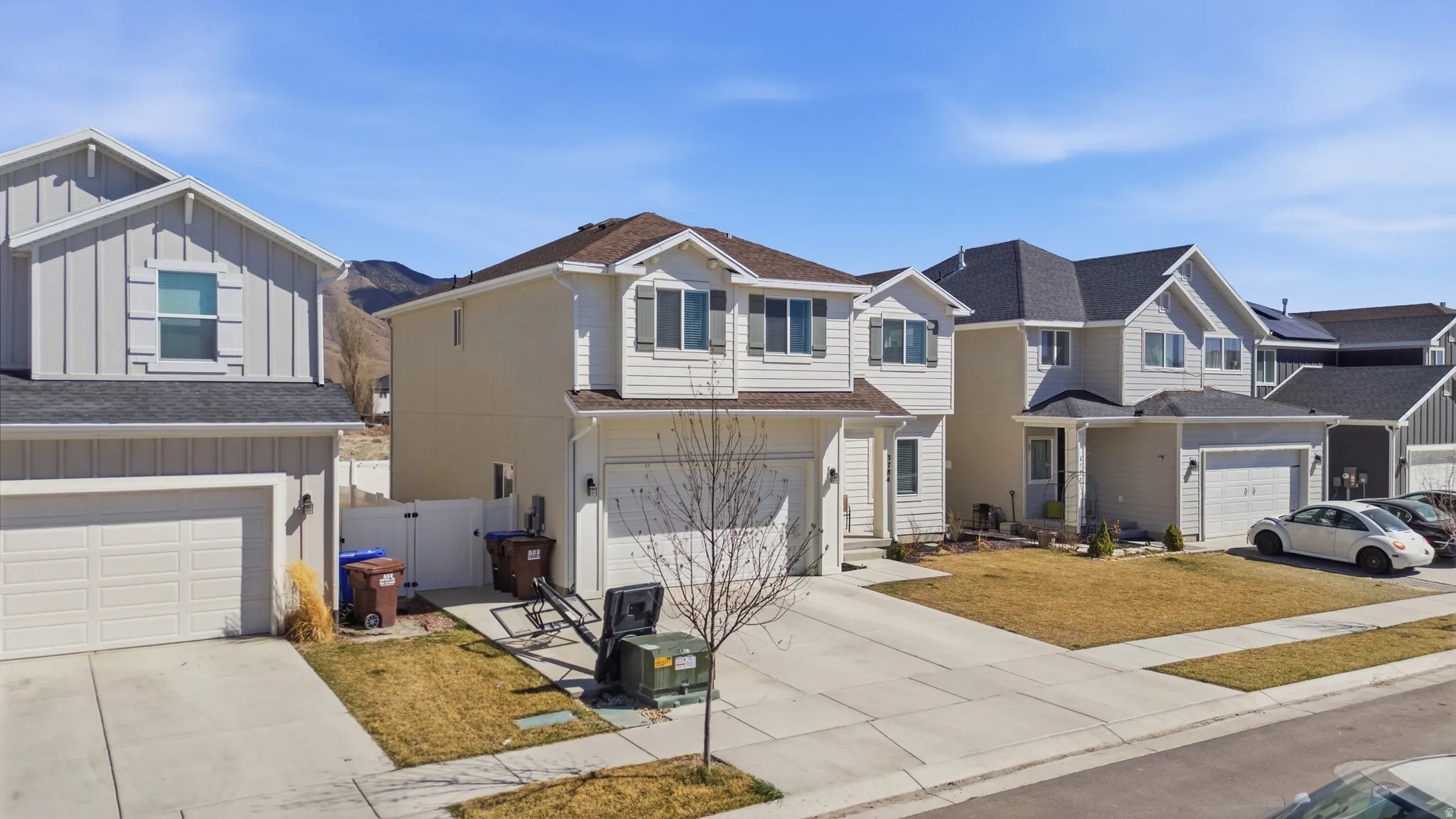 Traditional home featuring board and batten siding, a residential view, a gate, and driveway