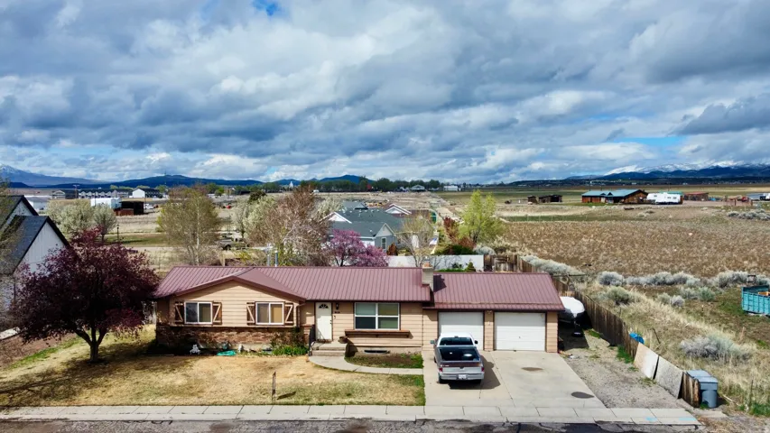View of front facade with a metal roof, a mountain view, concrete driveway, and a garage