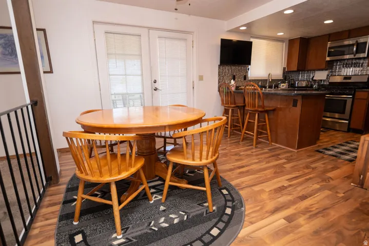 Dining space with recessed lighting, dark wood finished floors, and french doors