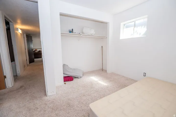 Unfurnished bedroom featuring light carpet and a closet