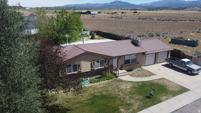 Ranch-style residence featuring a metal roof, attached two-car garage, and a concrete driveway