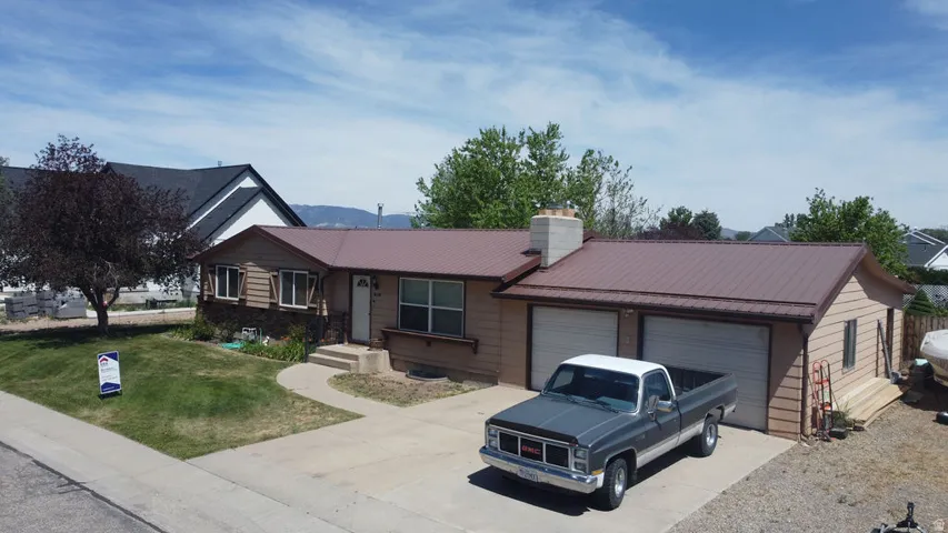 Single-story residence featuring a brown metal roof and light brown siding