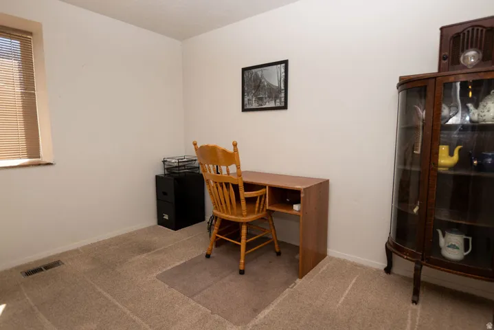 Office area featuring light carpet and baseboards