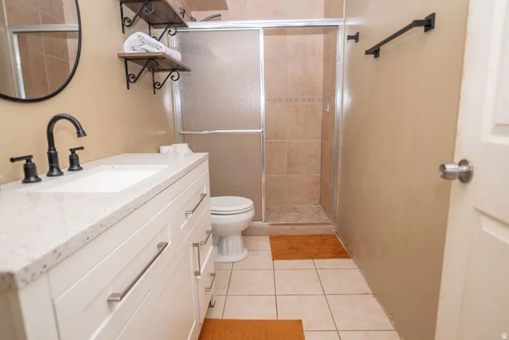 Bathroom with vanity, light tile patterned flooring, and a shower stall