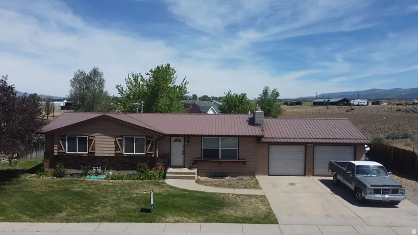 Ranch-style exterior featuring a brown metal roof, stone and siding facade, and decorative window shutters