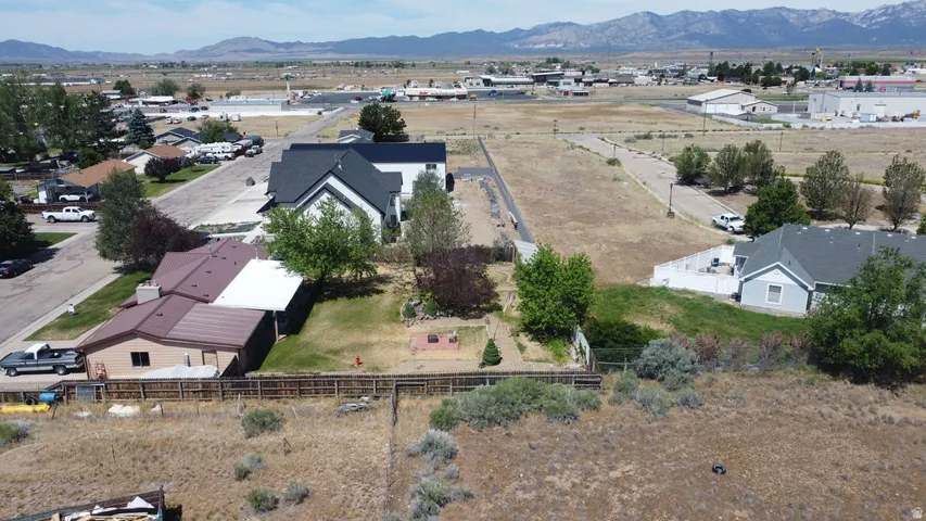 Residential property featuring a spacious lot, established landscaping, and mountain backdrop