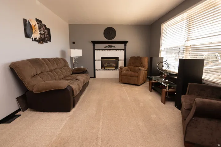 Living area with a fireplace and light colored carpet