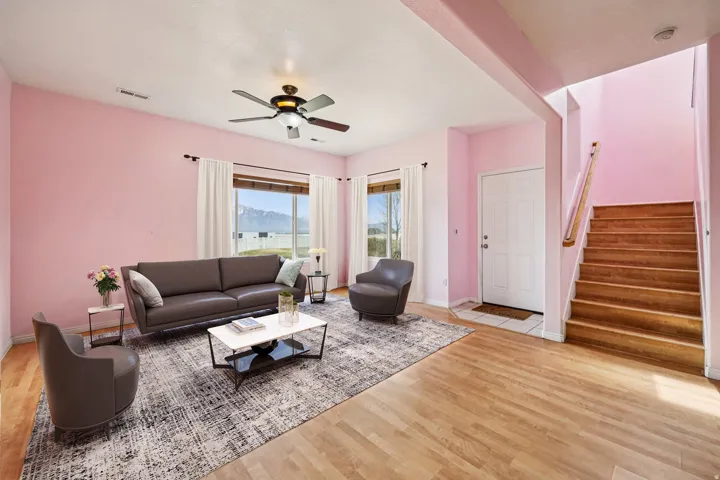 Living area with light wood-style flooring and a ceiling fan