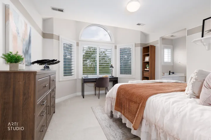Bedroom with light carpet and an office area