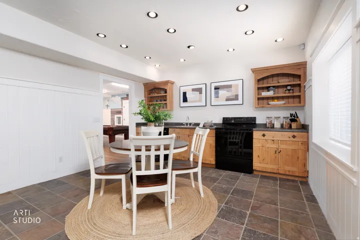 Dining room featuring a wainscoted wall, stone tile floors, recessed lighting, and wood walls
