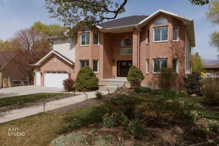 Traditional-style home featuring driveway and brick siding
