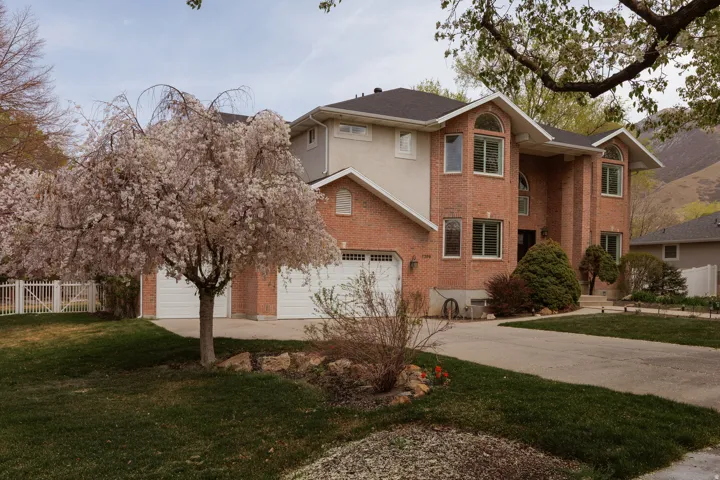 Traditional-style house featuring concrete driveway, brick siding, and a garage