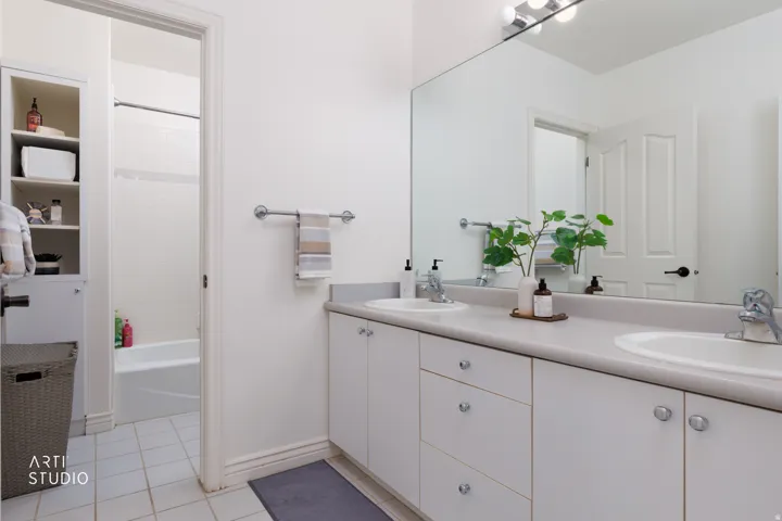 Bathroom with double vanity, light tile patterned floors, and tub / shower combination