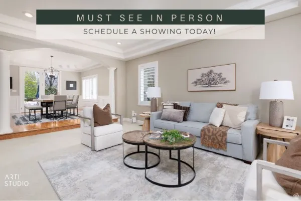 Bright, light-filled living room showcasing a gray upholstered sofa, wood-finish flooring, and neutral wall finishes