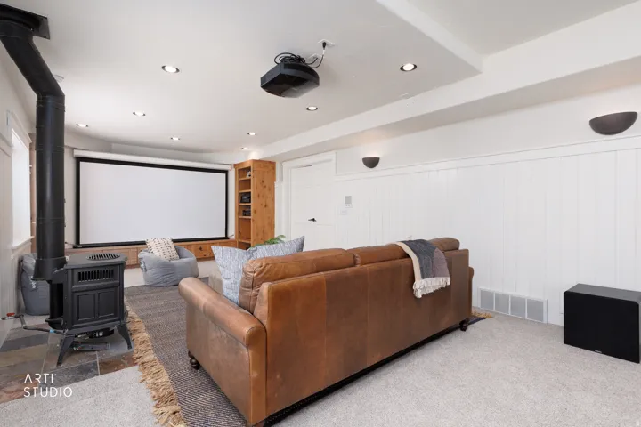 Cinema room featuring a wood stove, wainscoting, carpet floors, recessed lighting, and wood walls