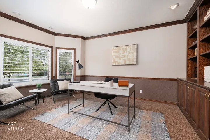 Home office featuring light carpet, a wainscoted wall, and crown molding