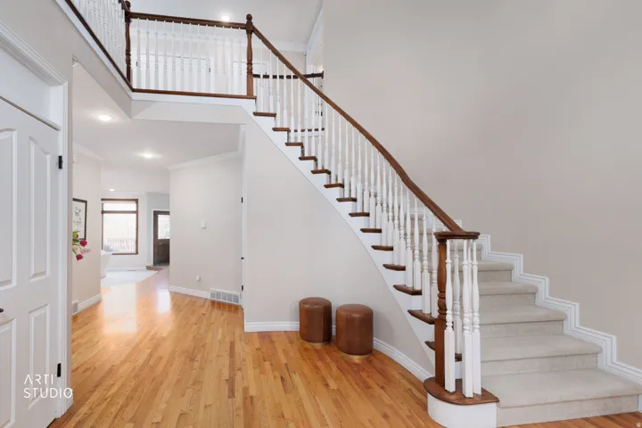 Stairway featuring ornamental molding, wood finished floors, a high ceiling, and recessed lighting