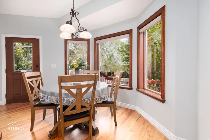 Dining area with light wood-style flooring and hanging lights