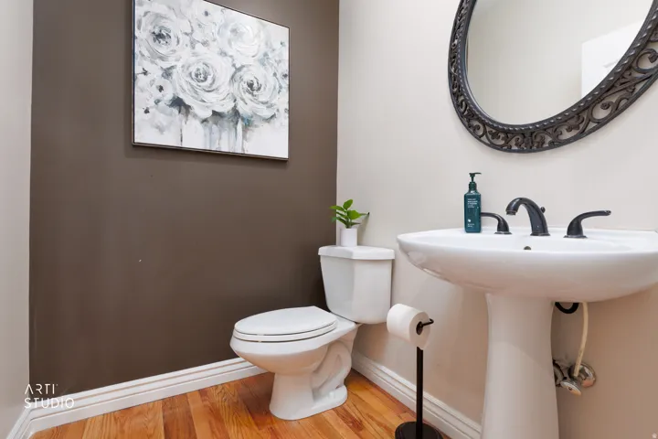 Half bathroom featuring toilet and light wood-style flooring