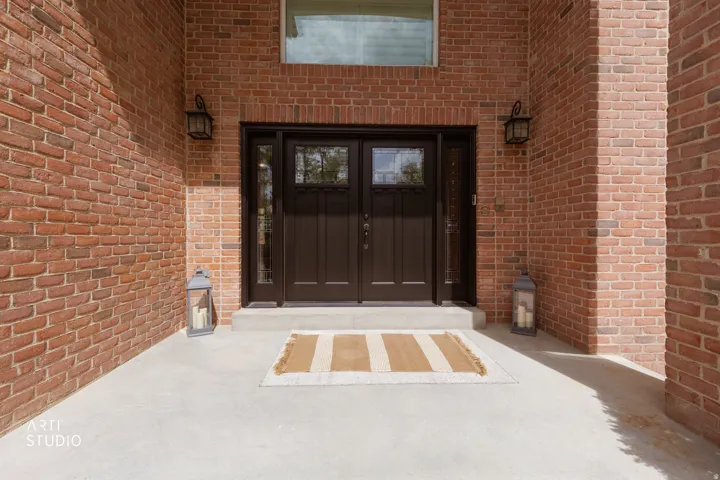 Entrance to property featuring brick siding, french doors, and a patio area