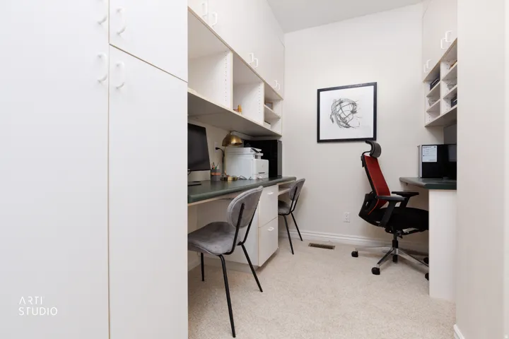 Office space with built in study area and light colored carpet