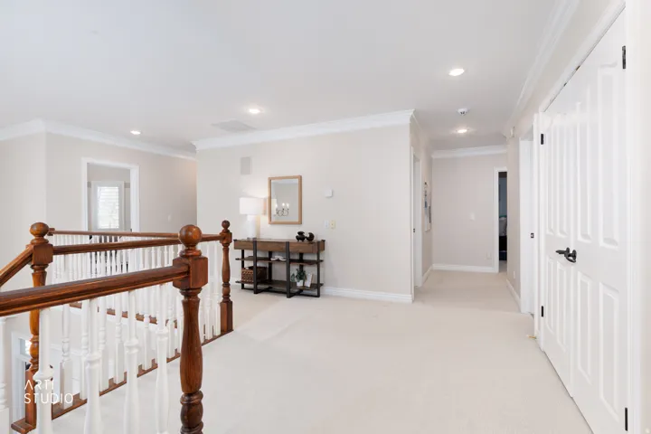Hallway featuring an upstairs landing, ornamental molding, light colored carpet, and recessed lighting