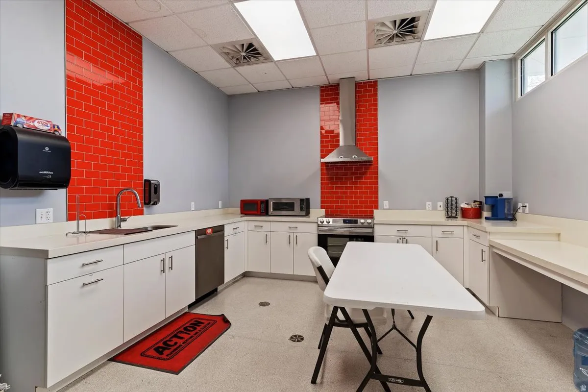 Kitchen featuring light countertops, white cabinets, stainless steel appliances, and a paneled ceiling