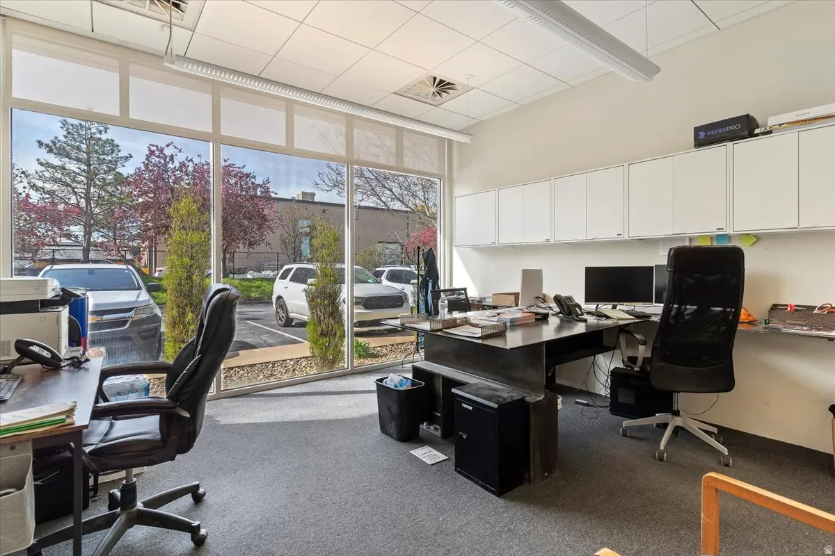 Office space featuring expansive windows and a high ceiling