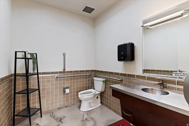 Bathroom 2 featuring vanity, tile walls, and wainscoting