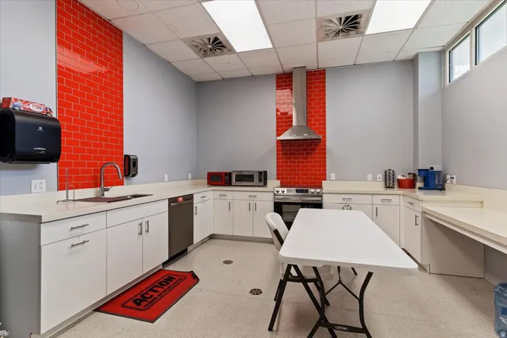 Kitchen featuring light countertops, white cabinets, stainless steel appliances, and a paneled ceiling