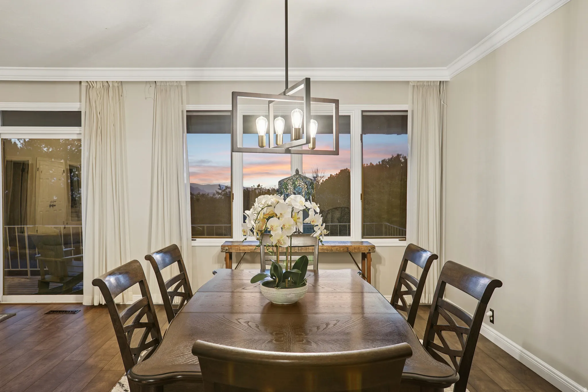Dining area with hardwood / wood-style flooring, hanging lights, and ornamental molding