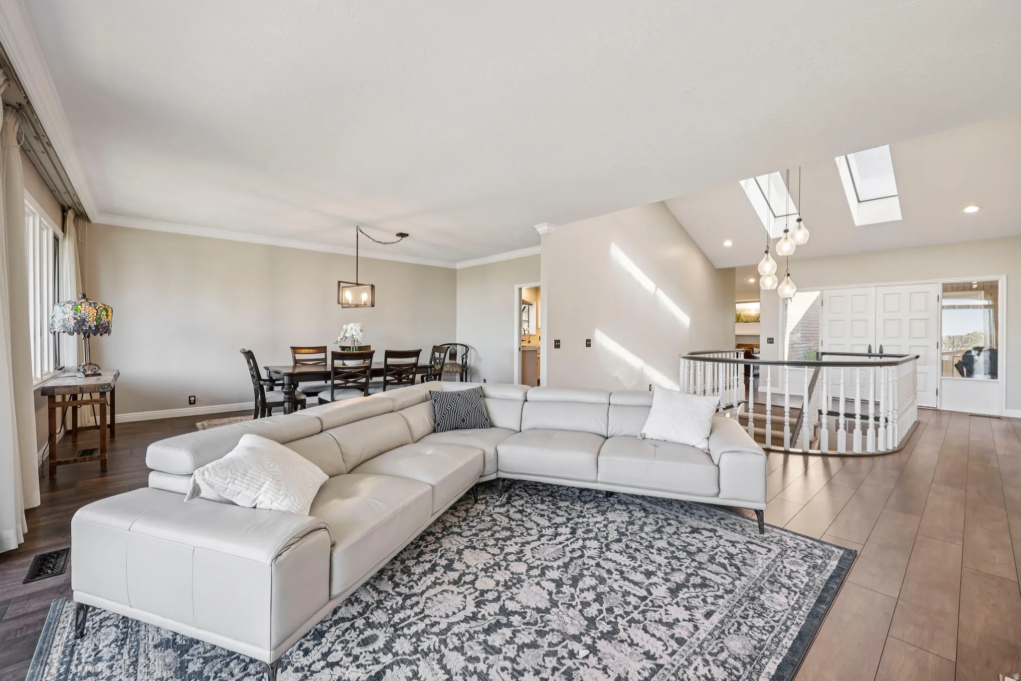Living room featuring dark wood-style flooring, a skylight, and recessed lighting