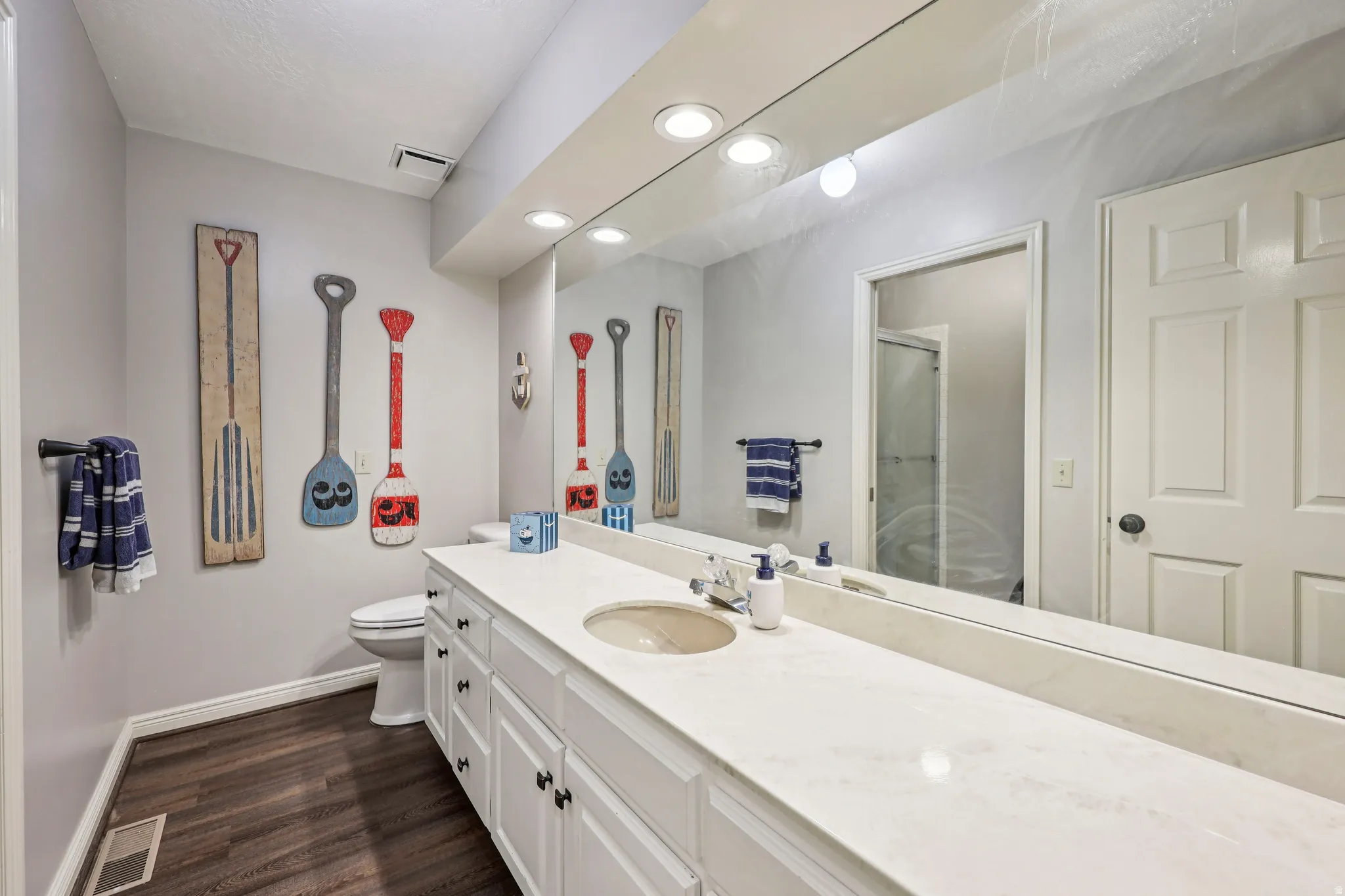 Bathroom with vanity, a stall shower, dark wood-type flooring, and recessed lighting