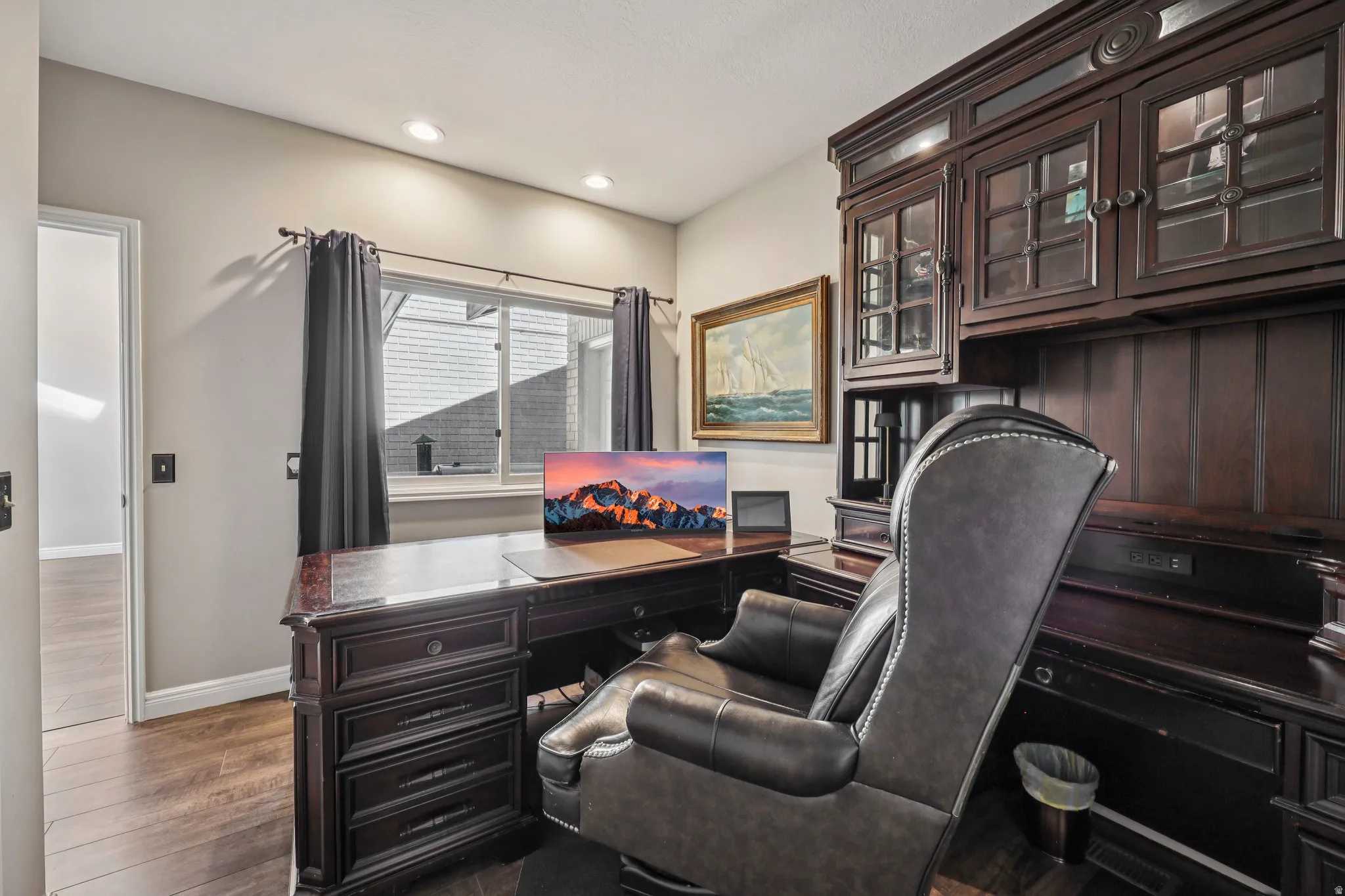 Office area with dark wood-type flooring and recessed lighting