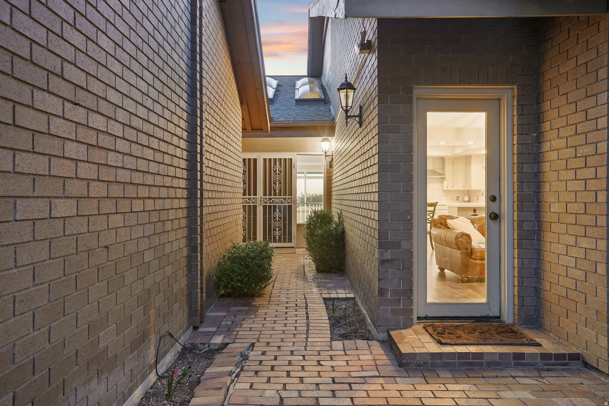Exterior entry at dusk with brick siding