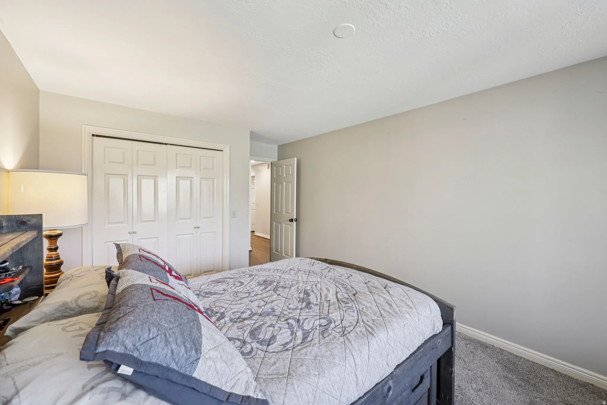 Carpeted bedroom with baseboards and a closet