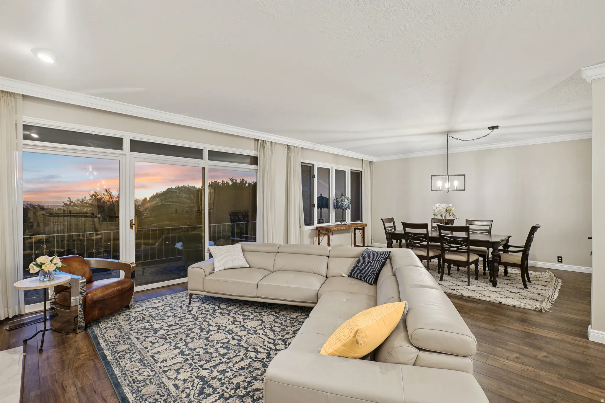 Living room featuring dark wood-style flooring and crown molding